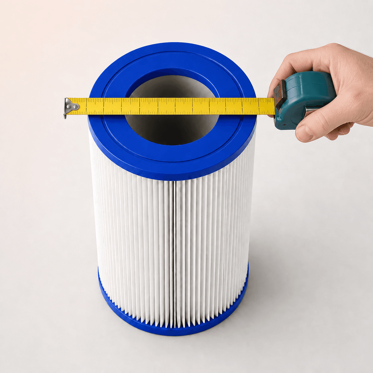 Hand holding a tape measure across the outside diameter of a pool filter cartridge